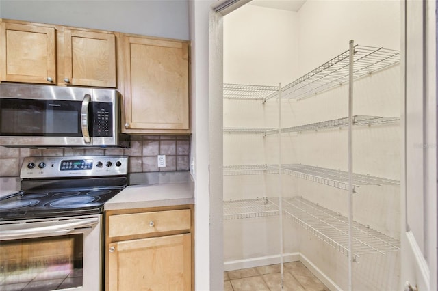 kitchen with decorative backsplash, appliances with stainless steel finishes, light brown cabinets, and light tile patterned floors