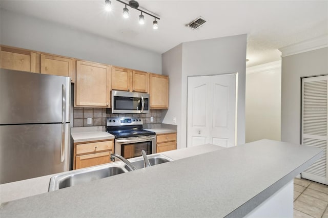 kitchen featuring sink, light brown cabinetry, backsplash, and appliances with stainless steel finishes