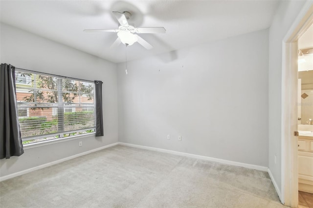 empty room featuring ceiling fan and light carpet