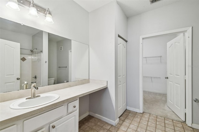 bathroom featuring a shower, vanity, and toilet