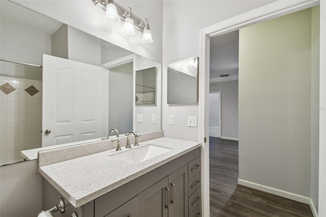 bathroom with hardwood / wood-style floors, vanity, and walk in shower