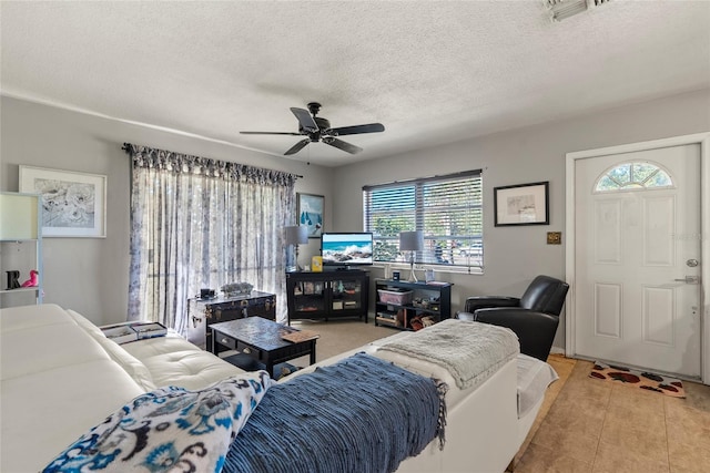 tiled living room featuring ceiling fan and a textured ceiling