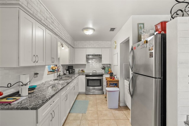 kitchen featuring appliances with stainless steel finishes, backsplash, sink, white cabinets, and light tile patterned flooring