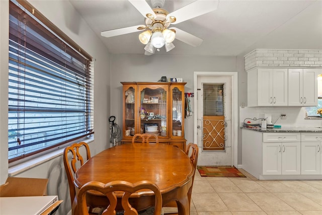 tiled dining room featuring ceiling fan