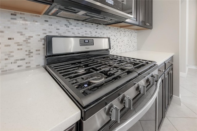 details featuring decorative backsplash and stainless steel gas range