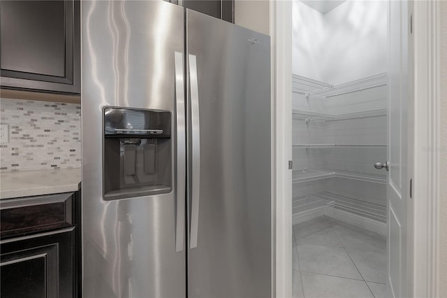 interior space with decorative backsplash, light tile patterned floors, and stainless steel refrigerator with ice dispenser