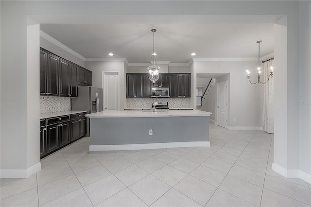 kitchen with pendant lighting, backsplash, a center island with sink, light tile patterned floors, and stainless steel appliances