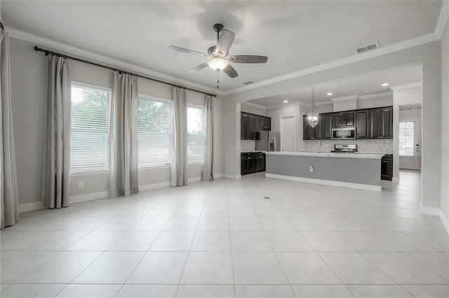 unfurnished living room featuring ceiling fan, ornamental molding, and a wealth of natural light