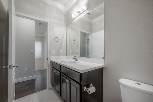 bathroom featuring tile patterned floors, crown molding, vanity, and toilet