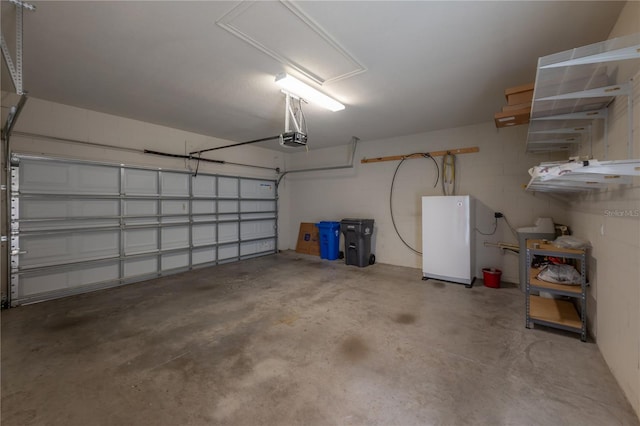 garage with white fridge and a garage door opener