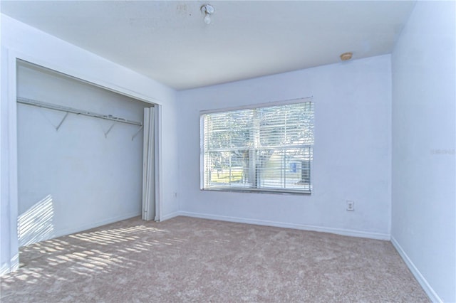 unfurnished bedroom with light carpet and a closet