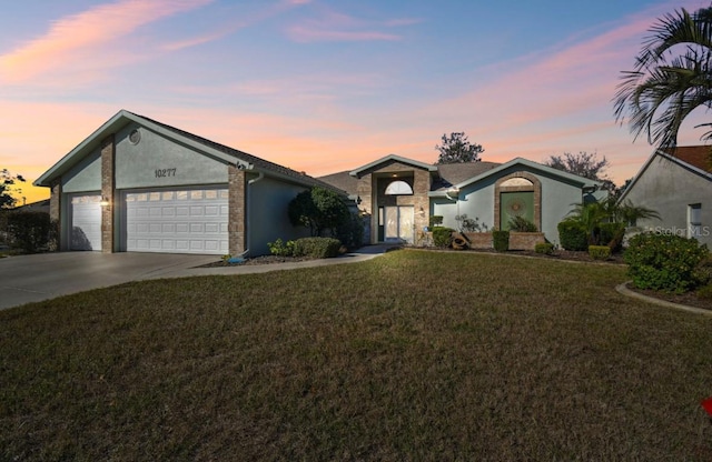 single story home featuring a yard and a garage