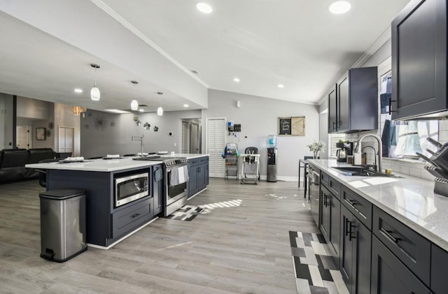 kitchen featuring sink, hanging light fixtures, lofted ceiling, appliances with stainless steel finishes, and ornamental molding