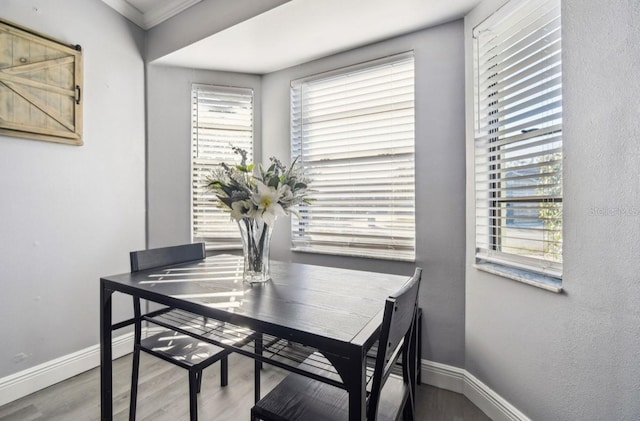 dining area featuring hardwood / wood-style floors, plenty of natural light, and crown molding