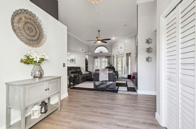 interior space with ceiling fan, light wood-type flooring, and ornamental molding