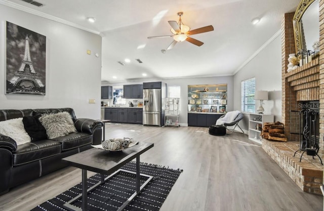 living room featuring hardwood / wood-style floors, vaulted ceiling, ornamental molding, and a healthy amount of sunlight