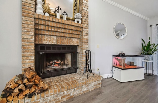 room details featuring wood-type flooring, crown molding, and a brick fireplace