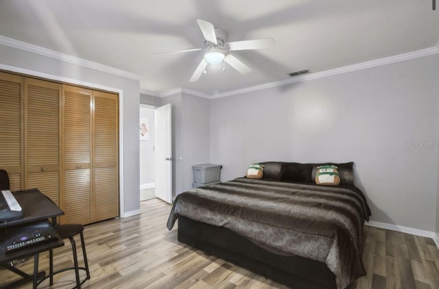 bedroom with hardwood / wood-style floors, ceiling fan, crown molding, and a closet