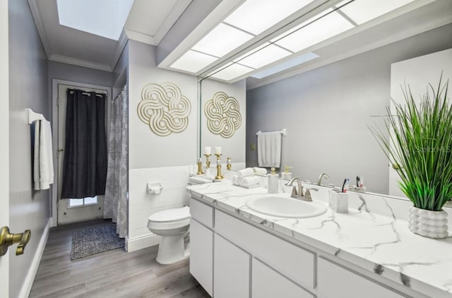 bathroom with crown molding, hardwood / wood-style floors, vanity, and toilet