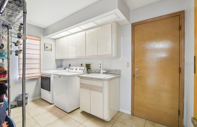 washroom with light tile patterned flooring, cabinets, independent washer and dryer, and sink