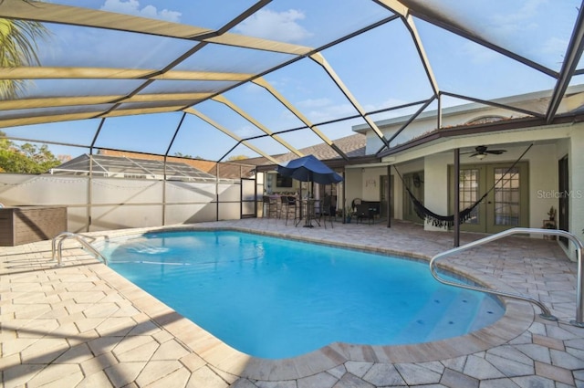 view of swimming pool with french doors, a patio area, ceiling fan, and a lanai