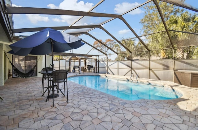 view of swimming pool featuring glass enclosure and a patio