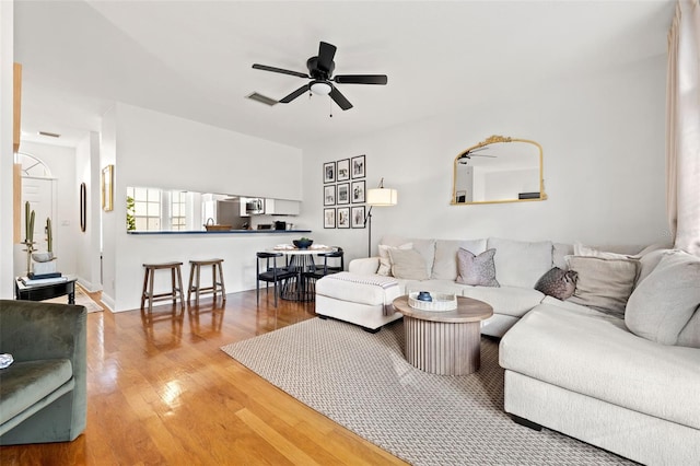 living room featuring wood-type flooring and ceiling fan