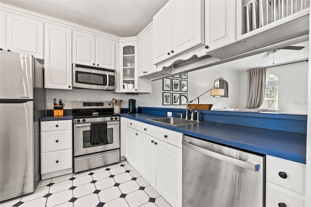 kitchen featuring white cabinets, stainless steel appliances, ceiling fan, and sink