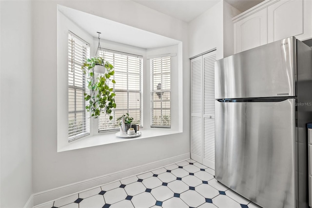 kitchen with stainless steel fridge and white cabinetry