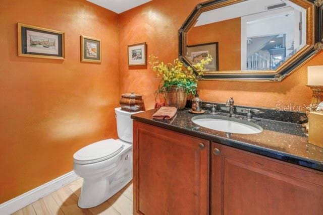 bathroom featuring hardwood / wood-style flooring, vanity, and toilet