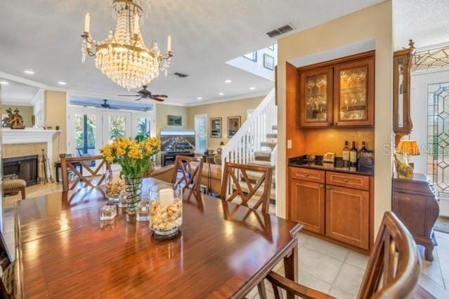 dining room with ceiling fan, light tile patterned flooring, crown molding, and french doors