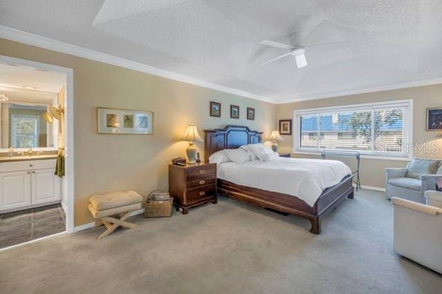 carpeted bedroom featuring a textured ceiling, connected bathroom, ceiling fan, and ornamental molding