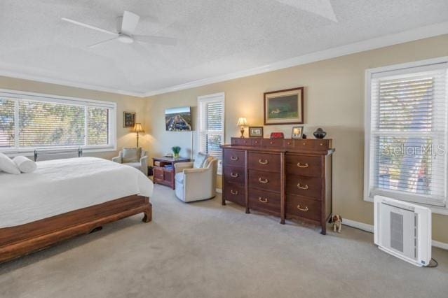 bedroom with ceiling fan, light colored carpet, a textured ceiling, and ornamental molding