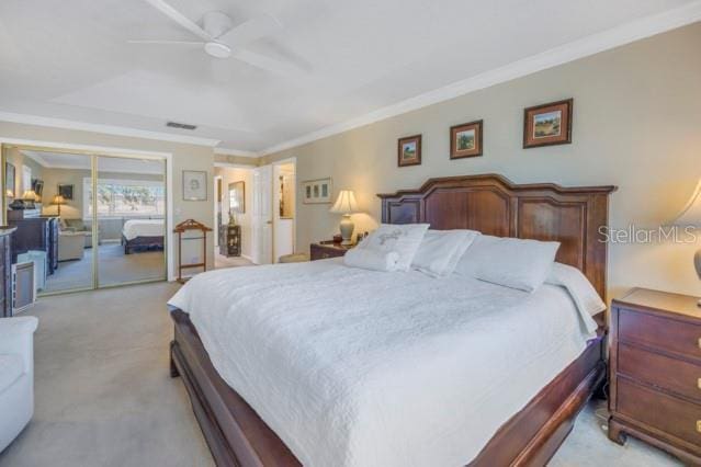 carpeted bedroom featuring ceiling fan, ornamental molding, and a closet