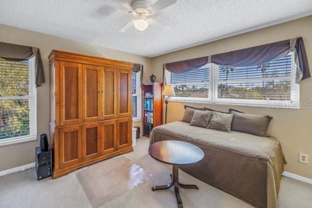 carpeted bedroom with a textured ceiling and ceiling fan