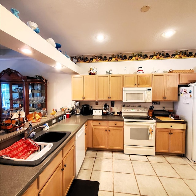 kitchen with light brown cabinetry, sink, light tile patterned flooring, and white appliances