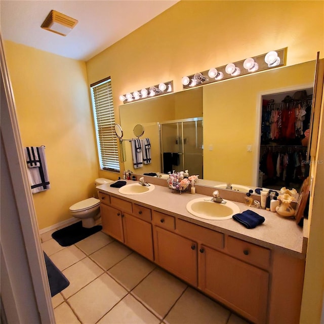 bathroom featuring tile patterned flooring, vanity, toilet, and a shower with door