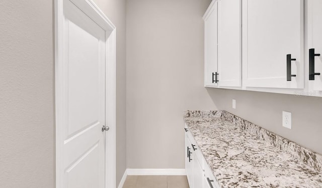 clothes washing area featuring light tile patterned floors