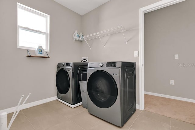 laundry room featuring light tile patterned floors and washer and clothes dryer