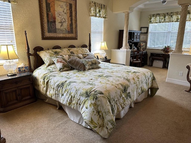 bedroom featuring crown molding, ornate columns, and light carpet