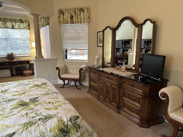 carpeted bedroom with ornate columns and multiple windows