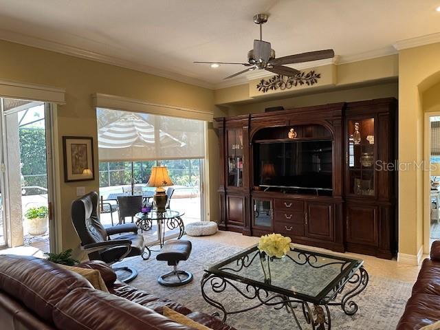 living room featuring crown molding, a ceiling fan, and recessed lighting