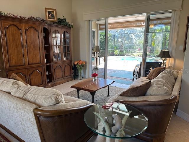living room featuring light tile patterned floors, baseboards, and a healthy amount of sunlight
