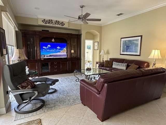 living room featuring visible vents, crown molding, a ceiling fan, arched walkways, and light tile patterned floors