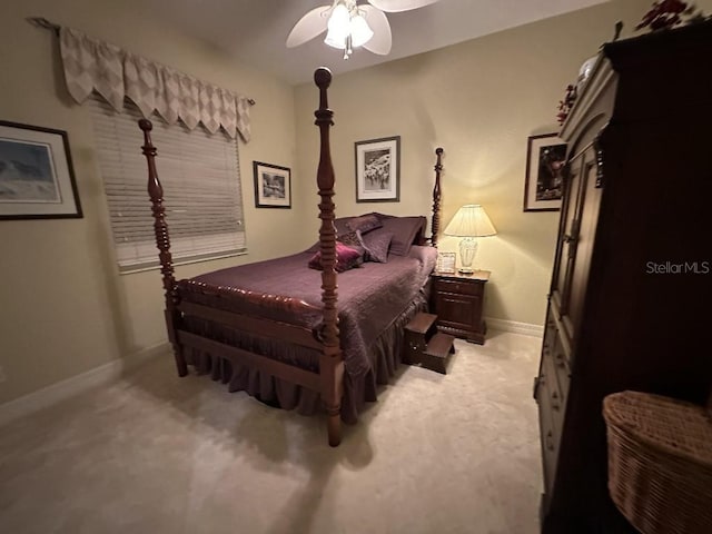 bedroom featuring baseboards, ceiling fan, and light colored carpet
