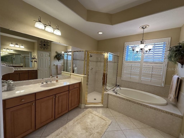 full bathroom with tile patterned flooring, vanity, a garden tub, a chandelier, and a shower stall