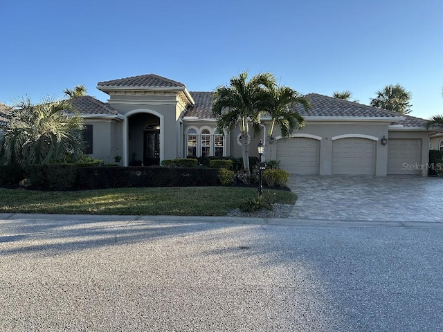 10626 Restoration Ter, Bradenton, FL 34212 - mediterranean / spanish-style house featuring an attached garage, decorative driveway, stucco siding, and a front lawn