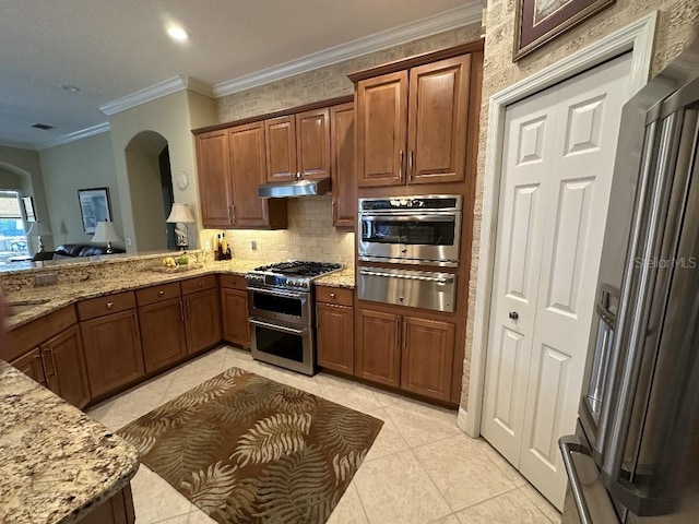 10626 Restoration Ter, Bradenton, FL 34212 - kitchen with a warming drawer, stainless steel appliances, arched walkways, light stone countertops, and ornamental molding
