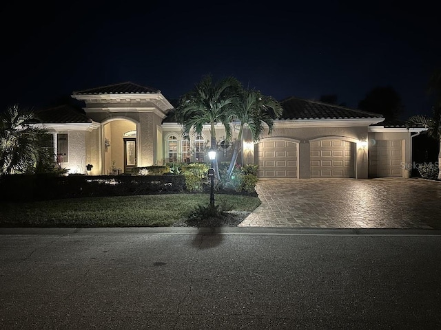 10626 Restoration Ter, Bradenton, FL 34212 - mediterranean / spanish-style house featuring a garage, decorative driveway, stucco siding, a yard, and a tile roof