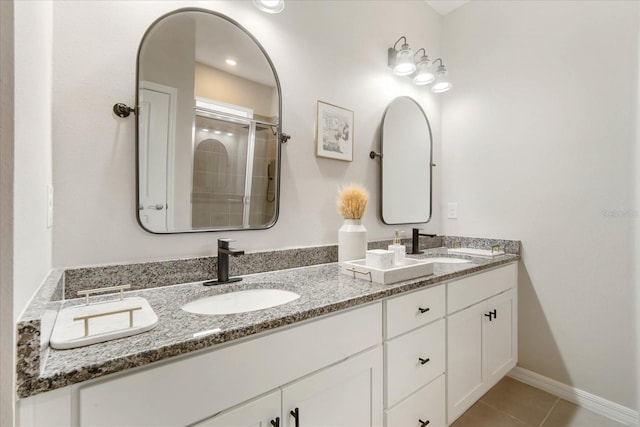 bathroom with tile patterned floors, a shower with door, and vanity